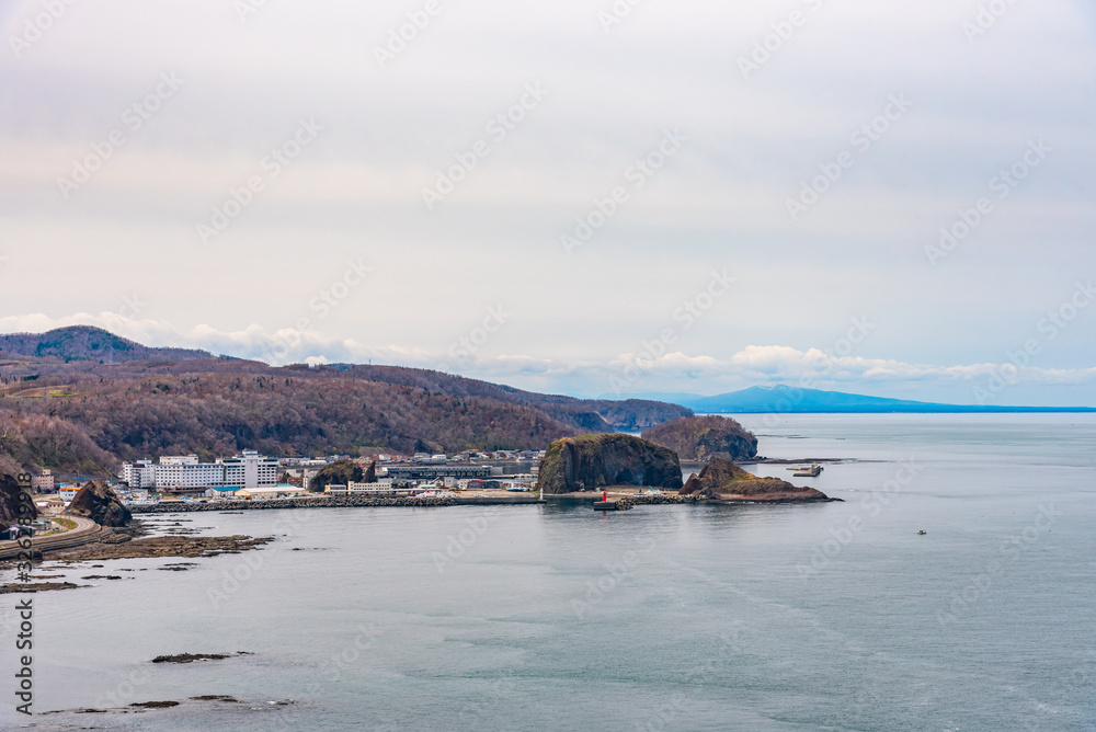 View of Utoro fishing port in springtime with Shiretoko mountain range at Utoronishi. Town Shari, Shiretoko Peninsula. Hokkaido, Japan