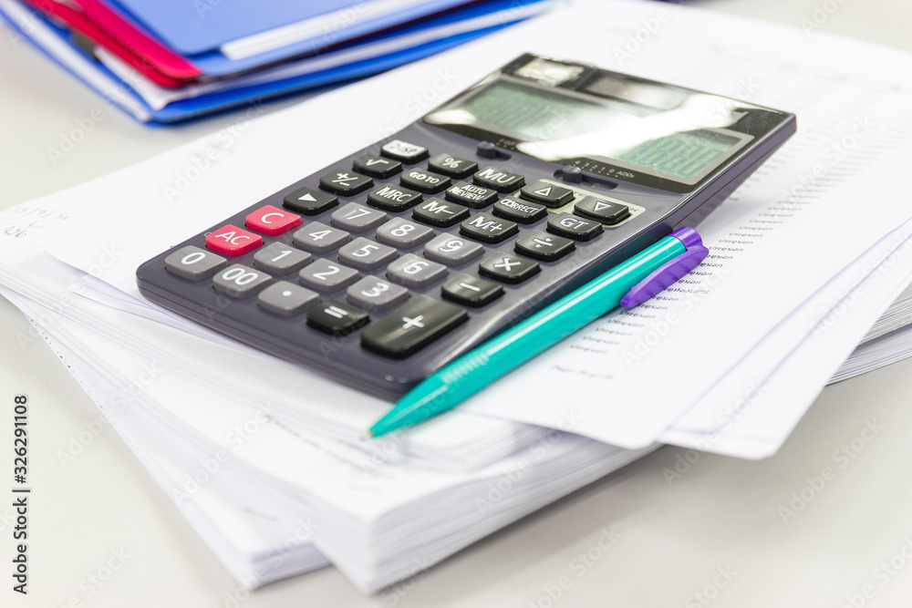 calculator with business paper on table in work office, concepts business and cost and financial planning calculator with business paper on table in work office, concepts business and cost and financial planning