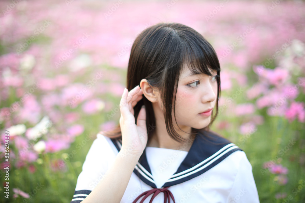 Portrait of Japanese school girl uniform with pink cosmos flower Portrait of Japanese school girl uniform with pink cosmos flower