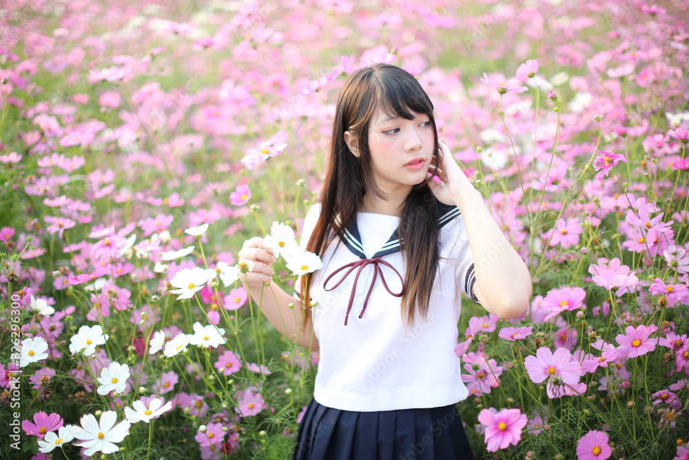 Portrait of Japanese school girl uniform with pink cosmos flower Portrait of Japanese school girl uniform with pink cosmos flower
