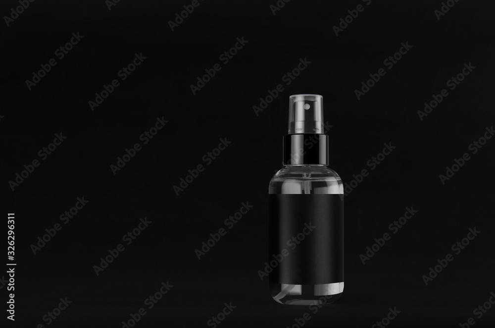 Elegant small transparent spray dispenser bottle for cosmetics with black label on dark black background, mock up for branding, design. Elegant small transparent spray dispenser bottle for cosmetics with black label on dark black background, mock up for branding, design.