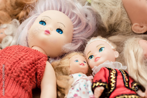 Many old dolls lies on floor in children room