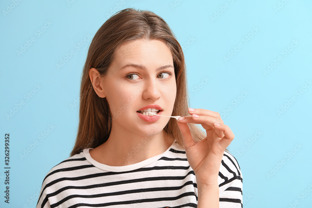 Funny young woman with chewing gum on color background Funny young woman with chewing gum on color background