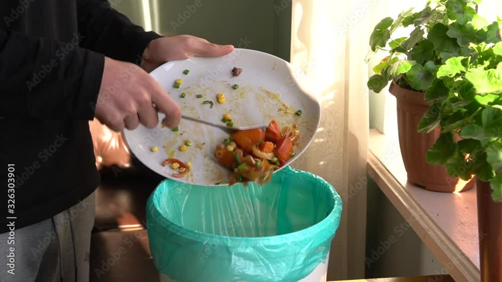 Food Waste Reduction. A man throws baked vegetables in the bin. The restaurant industry has a big food waste problem. Unused food in restaurants being disposed, recycled, or is donated