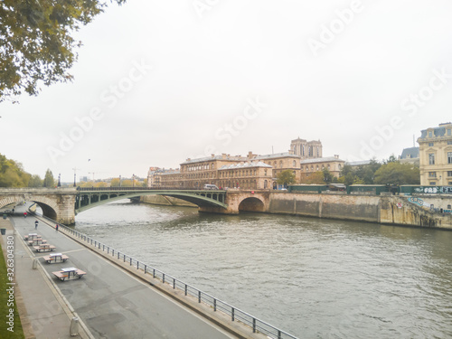Pont Notre-Dame, Paris, France. Beautiful shot of the bridge on a cloudy day with the "Hotel-Dieu" hospital in the background. The seine river docks in the foreground.  © Julien