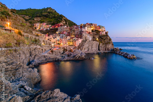 Fototapeta Naklejka Na Ścianę i Meble -  Sunset and night view of Manarola, one of the five Mediterranean villages in Cinque Terre, Italy, famous for its colorful houses and harbor