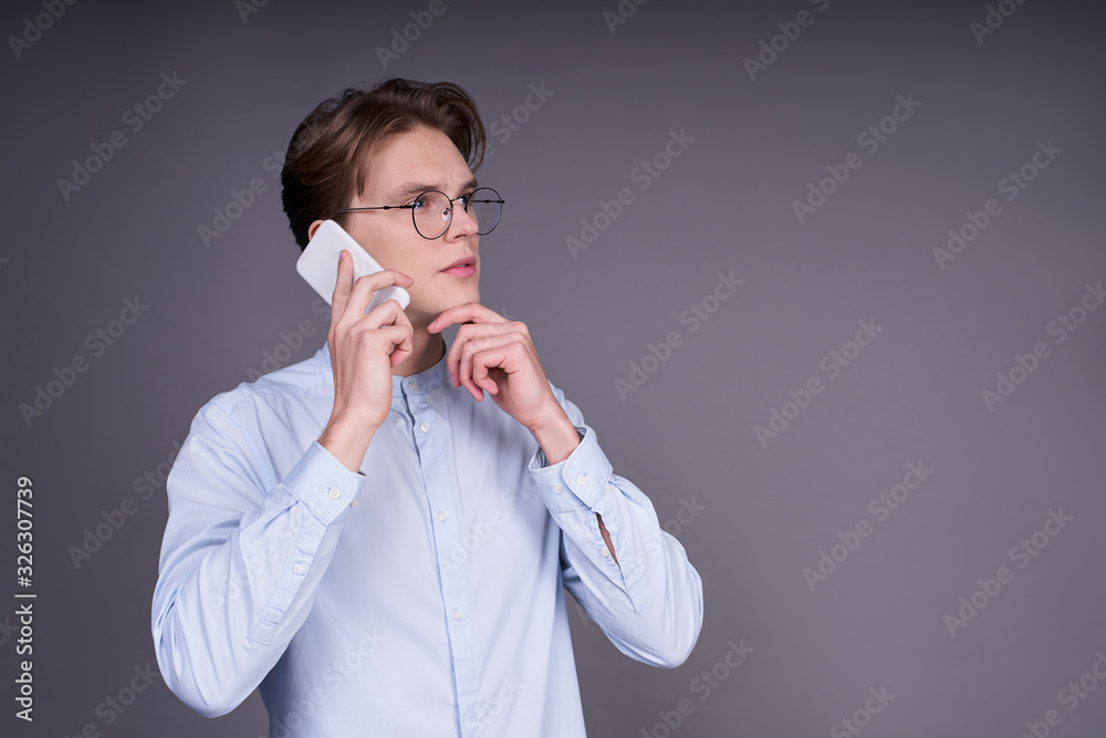 Cute young man in a blue shirt with a smartphone.