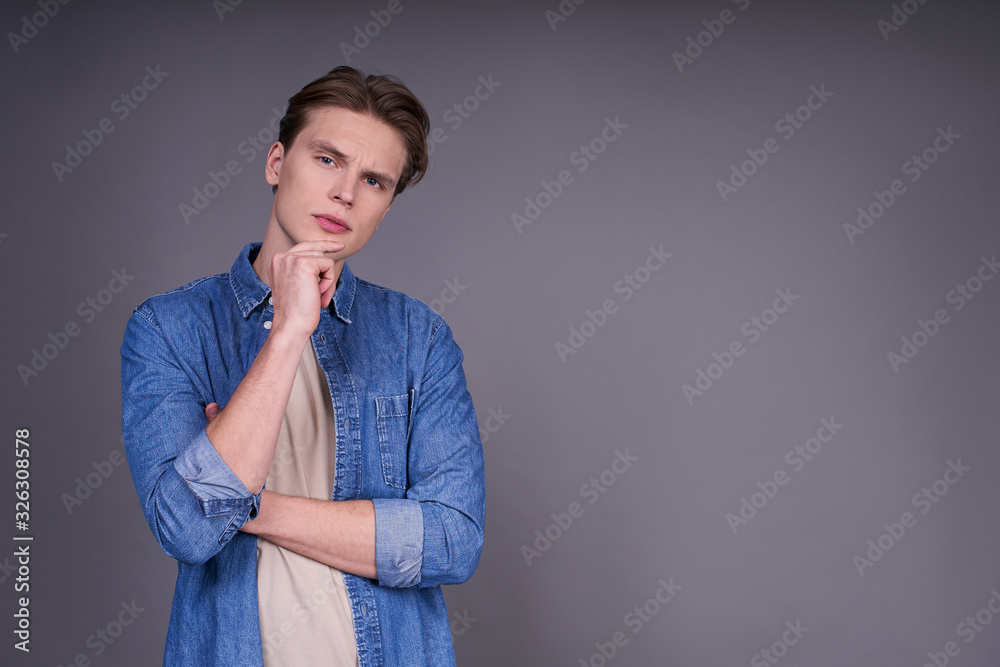 Calm young serious caucasian guy in a denim shirt. Calm young serious caucasian guy in a denim shirt.
