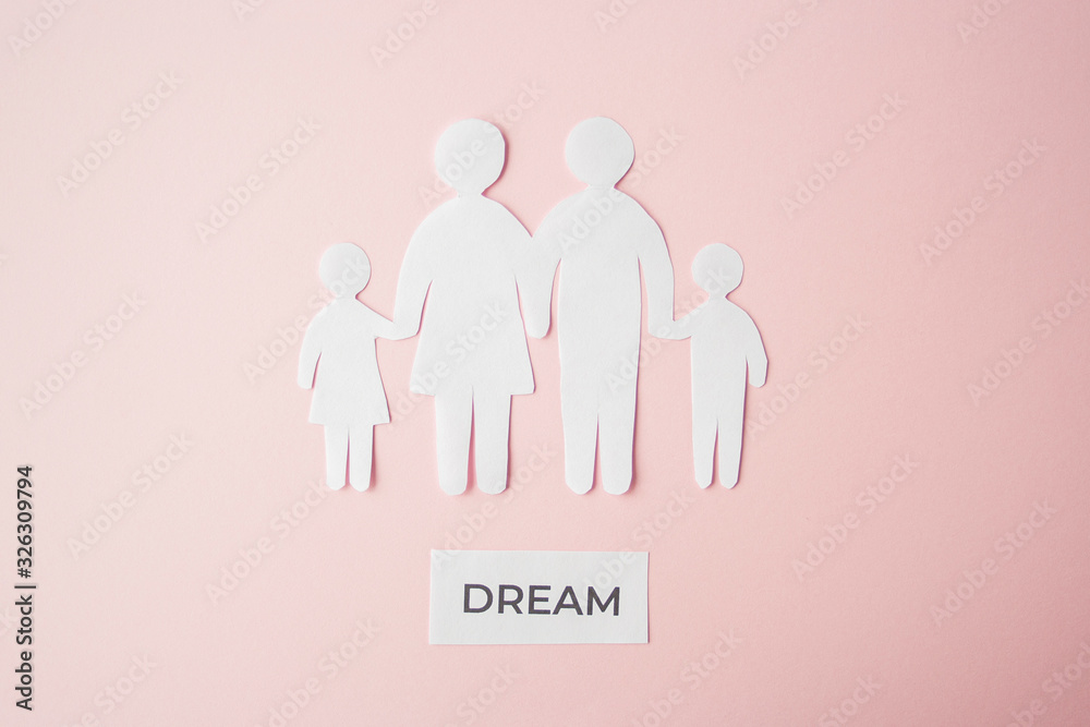 paper family cut out on bright pink background, family home, foster care, family dream, loneliness, life concept. Paper family with phrase quote Dream paper family cut out on bright pink background, family home, foster care, family dream, loneliness, life concept. Paper family with phrase quote Dream