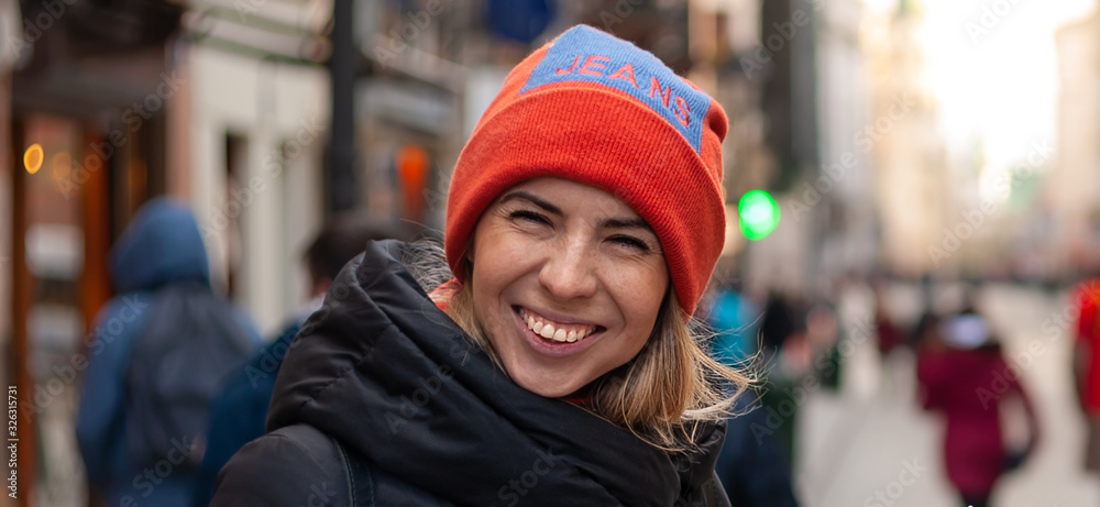 Beautiful blonde girl with naturally beautiful sun kissed face teeth smiling on blurred city background, sunny cold weather Beautiful blonde girl with naturally beautiful sun kissed face teeth smiling on blurred city background, sunny cold weather