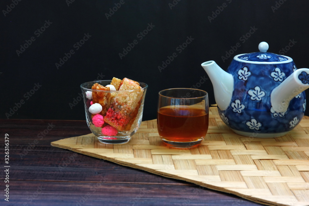 Chinese candy or dessert in glass with Chinese tea set isolate on black background. Chinese candy or dessert in glass with Chinese tea set isolate on black background.