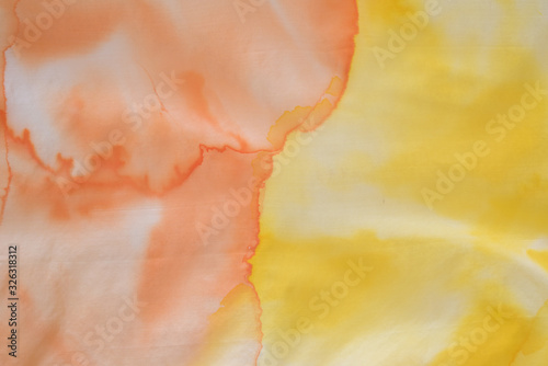 close up of hand colored orange and yellow silk scarf