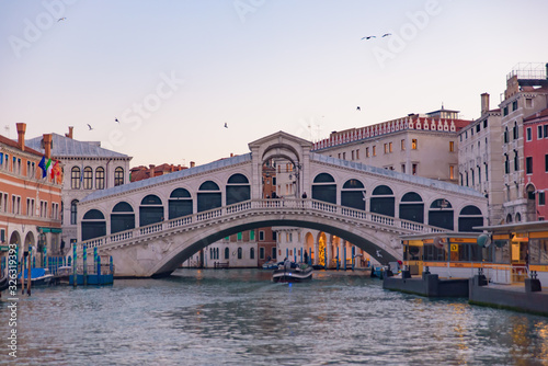 Rialto Bridge (Ponte de Rialto) across Grand Canal at sunrise / sunset time, Venice, Italy