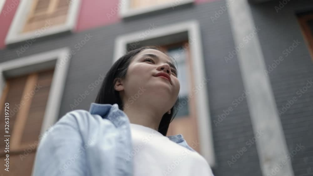 Attractive beautiful young asian woman looking out while standing a small street in the old town. Feeling happy freedom travel holiday weekend in Thailand. Attractive beautiful young asian woman looking out while standing a small street in the old town. Feeling happy freedom travel holiday weekend in Thailand.