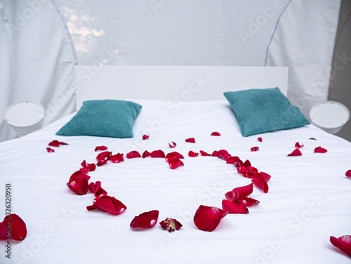 Romantisme - Coeur en pétales de rose sur le lit photo