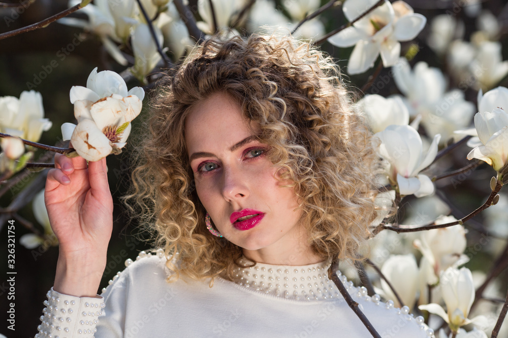 Fototapeta premium Woman portrait in white blouse in magnolia garden