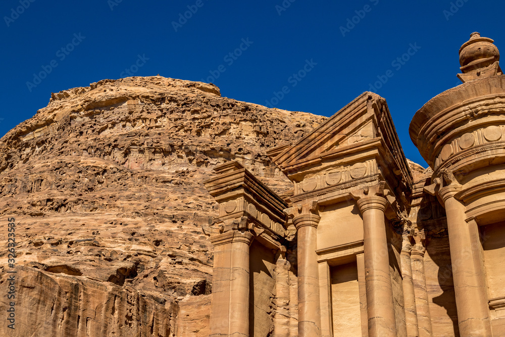 Sunny cloudless day close-up detailed view of the stunning Ad-Deir in the ancient city of Petra, Jordan. Ad-Deir or The Monastery. Petra complex and tourist attraction, Hashemite Kingdom of Jordan