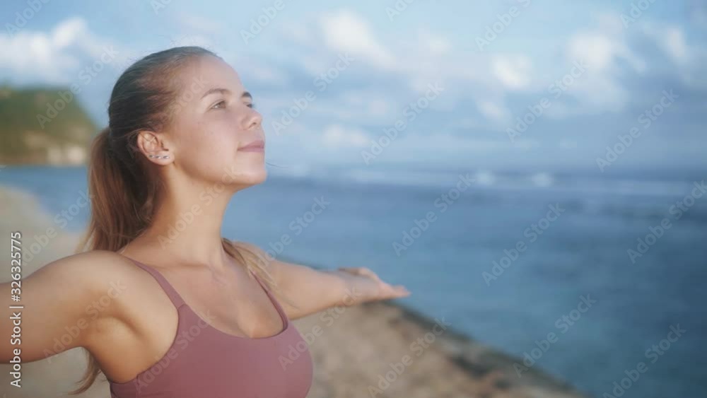 Portrait of woman practices yoga, concentrates on breathing at beach, slow motion Portrait of woman practices yoga, concentrates on breathing at beach, slow motion