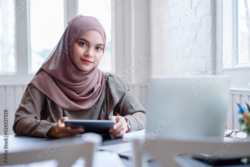 Happy professional arab businesswoman brown hijab working at home.
