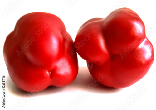 male three-chamber and female four-chamber two red sweet peppers on a white background