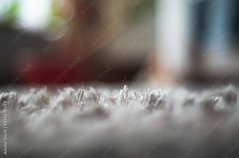 Low angle macro view of a carpet hair with a colorful background