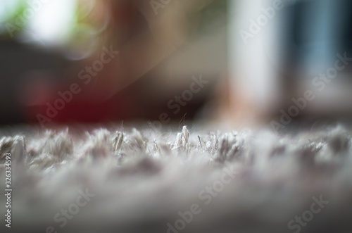 Low angle macro view of a carpet hair with a colorful background