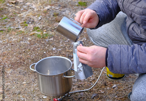 Obraz na plátně Traveler is eating freeze dried food during camping