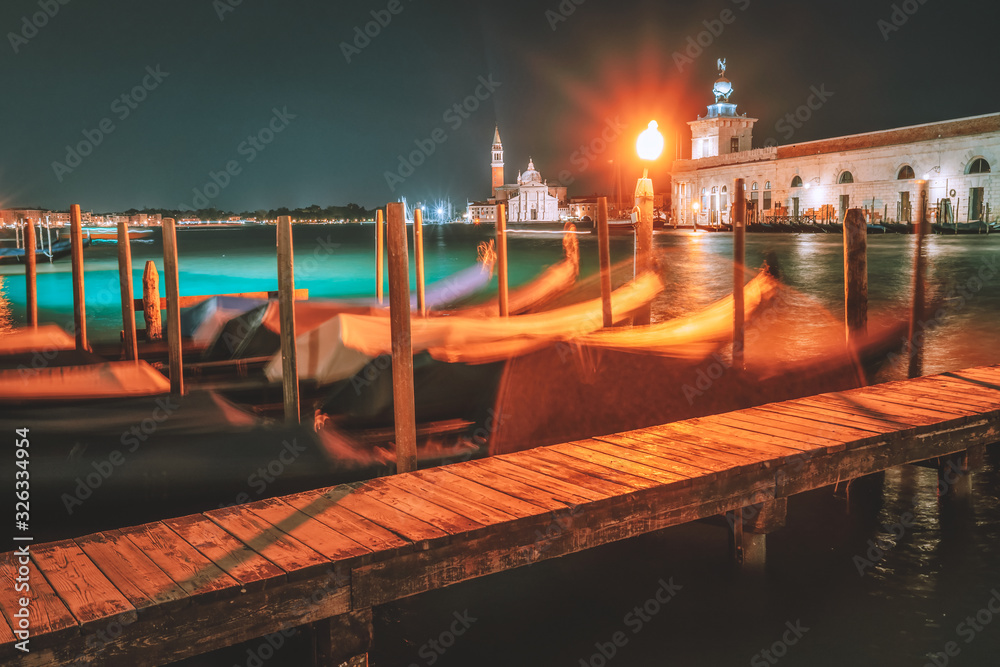 Venice night landscape from city canal with gondolas anchored on Grand Canal - long exposure shot with motion blurred gondolas