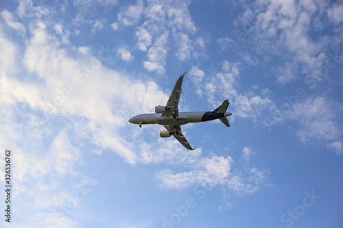 Big white airplane flying in the blue skyplane with white clouds. Plane on a background of blue sky. Place for text