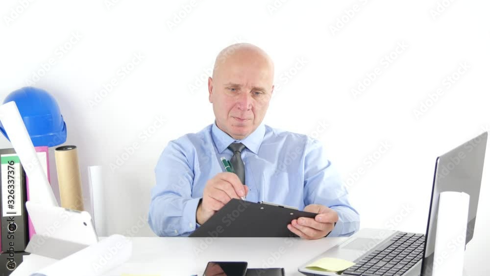 Businessman in Office Room Taking Notes on a Clipboard, Man Working in Office Room Writing Information in Agenda Businessman in Office Room Taking Notes on a Clipboard, Man Working in Office Room Writing Information in Agenda
