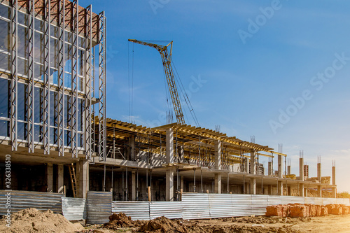 Construction site background. Hoisting cranes and new multi-storey buildings. I.ndustrial background.Building construction site work against blue sky