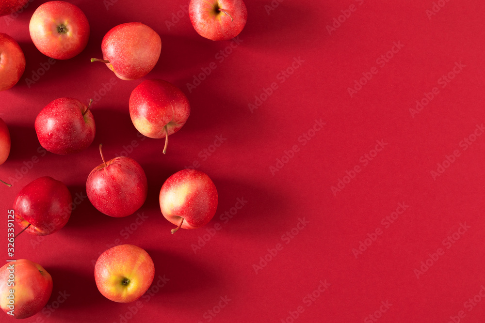 Red apples on red background. Apples as background. Flat lay, top view, copy space - obrazy, fototapety, plakaty 