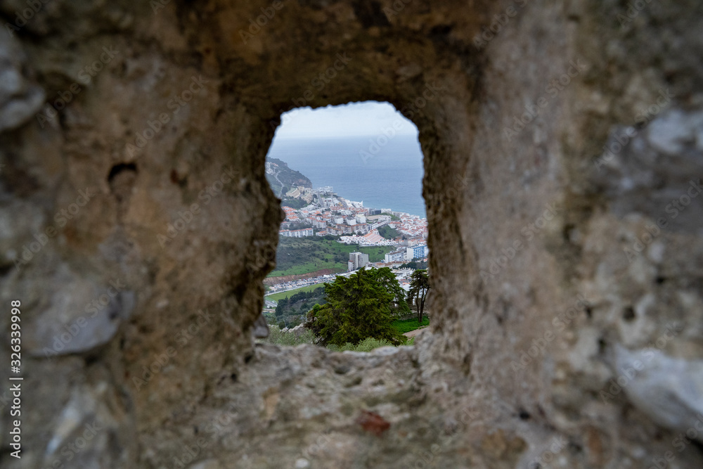 Unique view of Sesimbra, Portugal (aerial view) from a window hole in the castle walls
