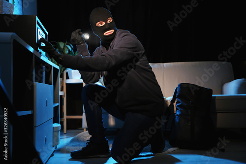 Fototapet Thief with flashlight near steel safe indoors at night