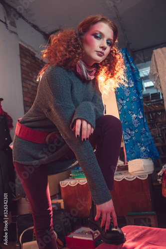 Beautiful curly red-haired girl in the Soviet room. photo