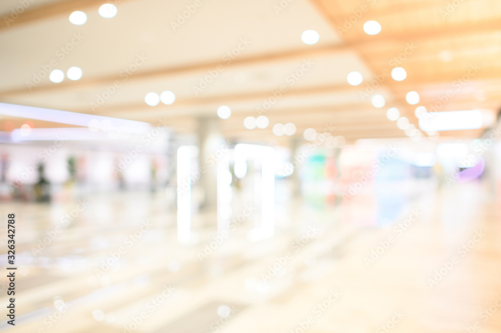 Abstract blur shopping mall corridor. Blurred retail and hall interior in department store. Defocused bokeh effect background or backdrop for business concept.