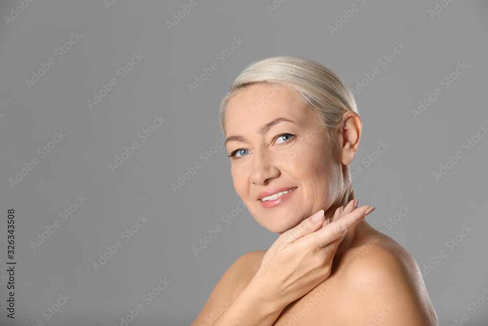 Portrait of beautiful mature woman on grey background. Space for text Portrait of beautiful mature woman on grey background. Space for text