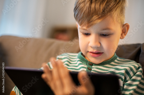 childhood, technology and people concept - happy little boy with tablet pc computer at home