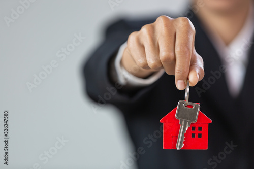 Real estate agents hold home keys for customers. Ideas for real estate, moving houses or renting real estate.Businessmen catch the key.For home trading.There is space for entering text.