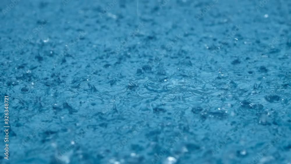 Close-up rain, raindrops falling in a large puddle in slow motion. Rain season. Close-up rain, raindrops falling in a large puddle in slow motion. Rain season.