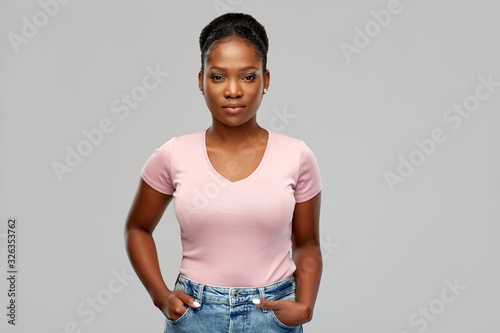 people, ethnicity and portrait concept - african american young woman over grey background