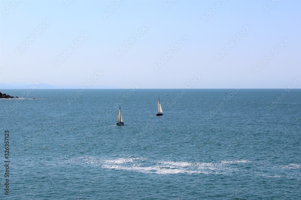  a small sailboat plows the Mediterranean sea