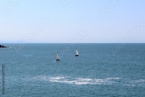  a small sailboat plows the Mediterranean sea