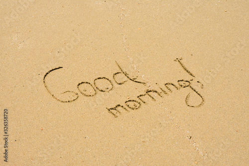Text Good Morning on sand