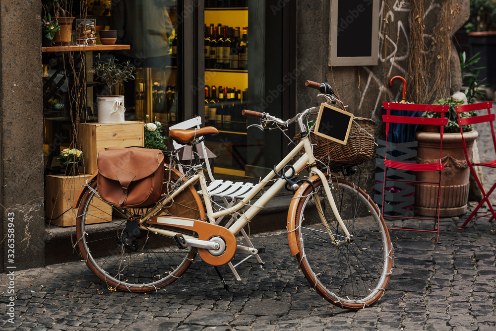 Bicycle next to a restaurant, pretty streets of small italian villages. Vintage old bike - charming street decoration. Artwork in retro style. Copy space.