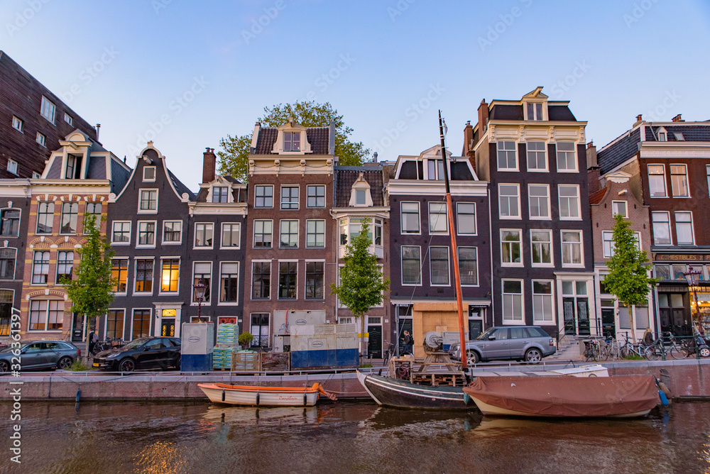 Buildings and boats along the canal at sunset time in Amsterdam, Netherlands