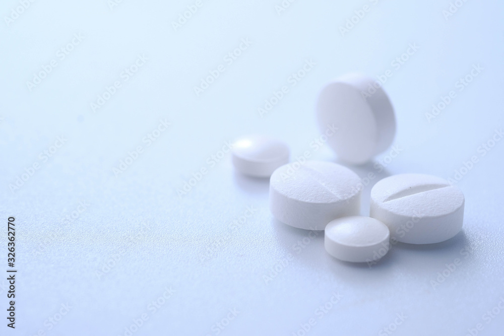 Close up of white pills on white background 