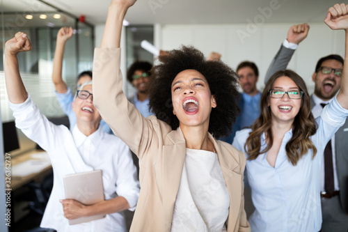 Happy business people celebrating success at company. © NDABCREATIVITY