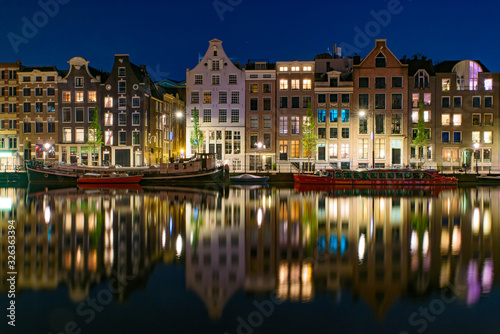 Reflection of the buildings along the canal at night in Amsterdam, Netherlands