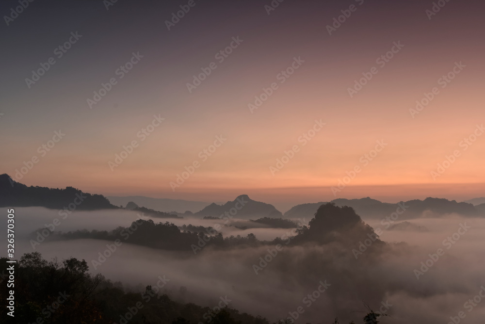 Beutiful sea of fog in a valley with orange sky cloud in a sunrise time Beutiful sea of fog in a valley with orange sky cloud in a sunrise time